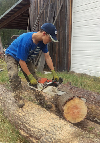 Picture of Zane cutting wood with chain saw